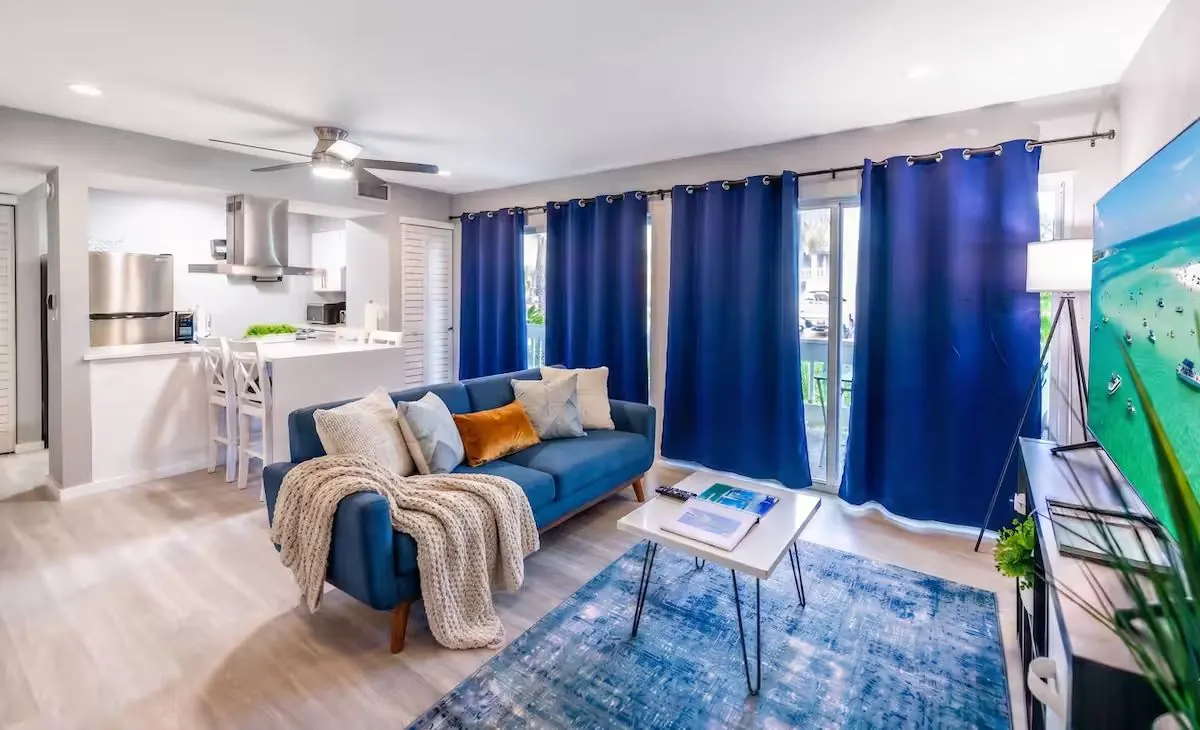 Bright living room with open kitchen and coastal-blue accents
