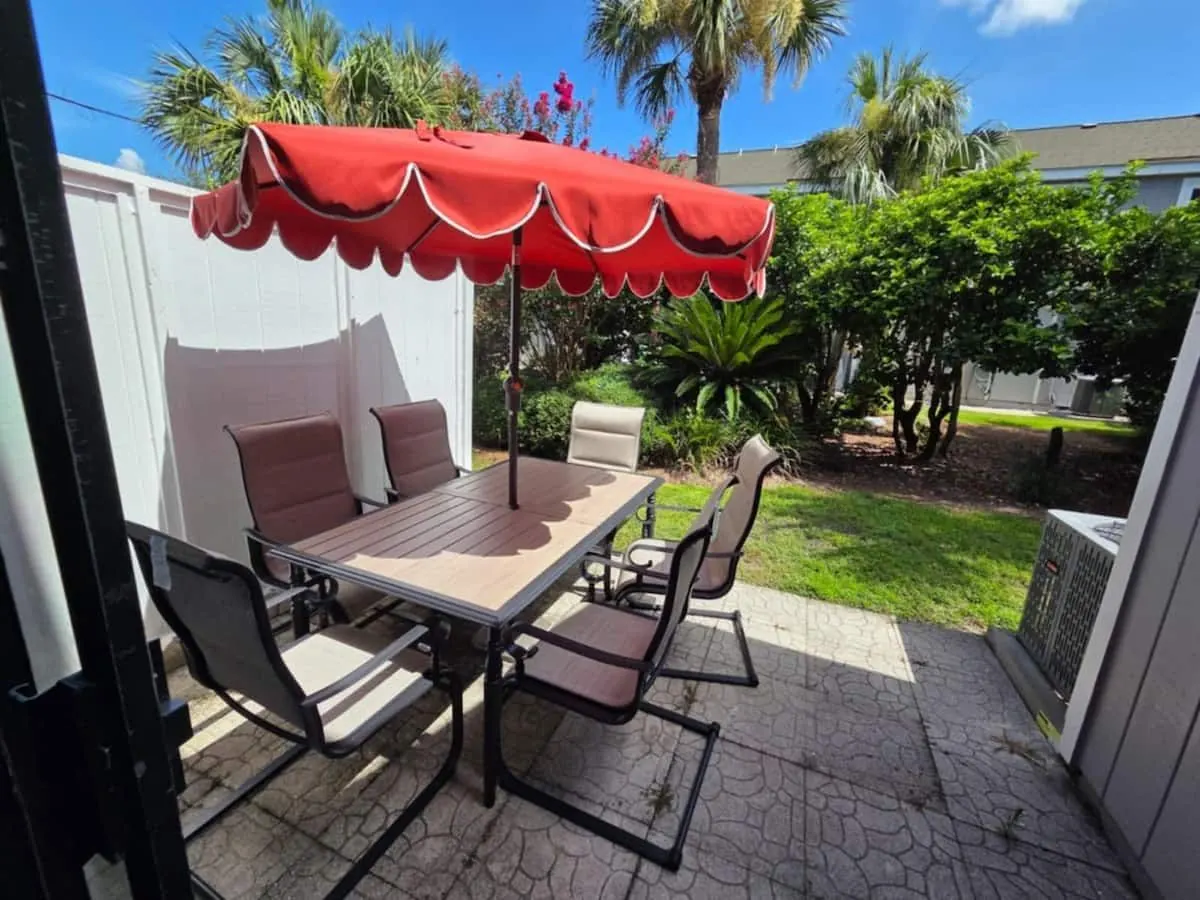 Outdoor patio with dining table and red umbrella